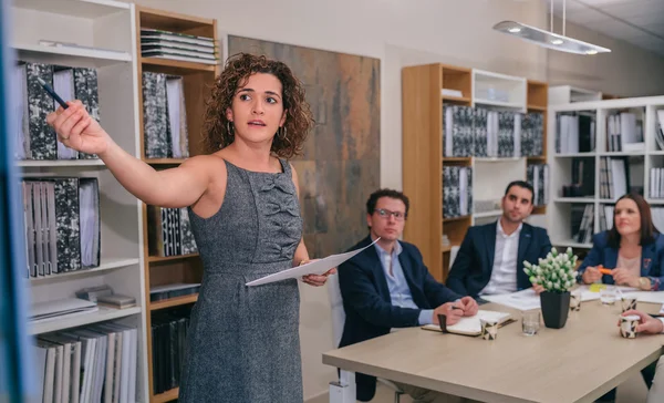 Coach mujer explicando proyecto a equipo de negocios — Foto de Stock