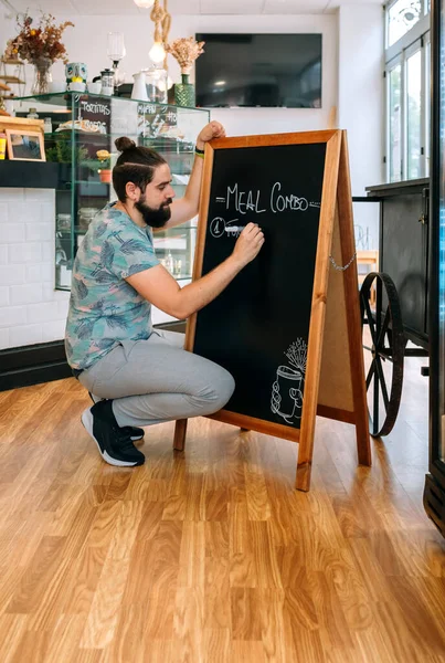 Young waiter writing the daily menu — Stock Image Young waiter writing the daily menu Stock Picture