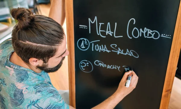 Closeup of young waiter writing the daily menu — Stock Image Closeup of young waiter writing the daily menu Stock Photo