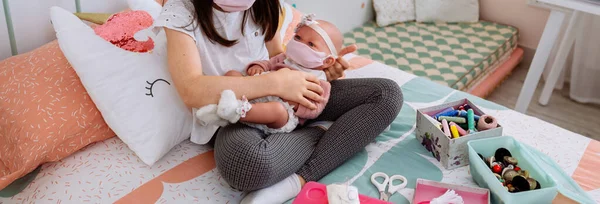 Chica con máscara jugando a cuidar de su muñeca con máscara — Foto de Stock