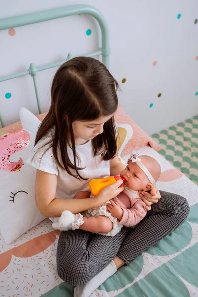 Gadis kecil bermain makan boneka bayinya — Stok Foto