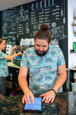 Kahve dükkanı sahibi iş hesaplarını inceliyor.