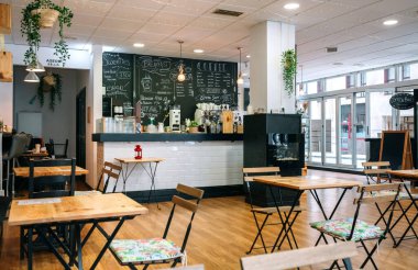 Sandalyeleri ve masaları olan boş modern bir kafe.