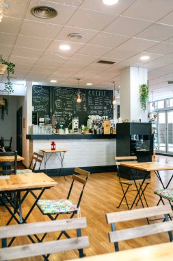 Sandalyeleri ve masaları olan boş modern bir kafe.