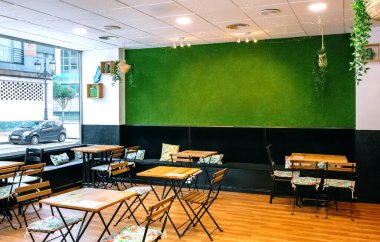 Yapay çim duvarlı içi boş bir kafe.