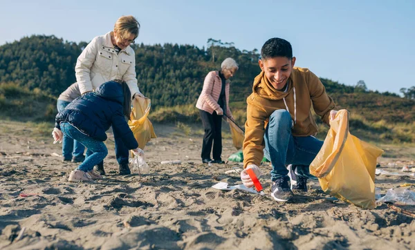 Молодой человек убирает пляж — стоковое фото