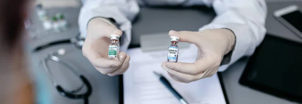 Ärztin zeigt ihrer Patientin zwei verschiedene Coronavirus-Impfstoffe — Stockfoto