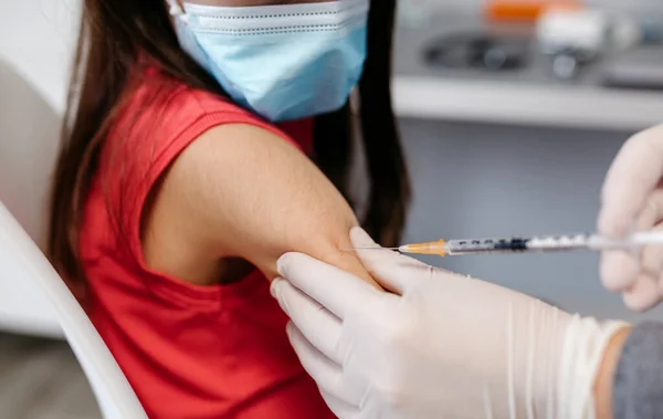 医師事務所でコロナウイルスワクチンを受けている少女の閉鎖 — ストック写真