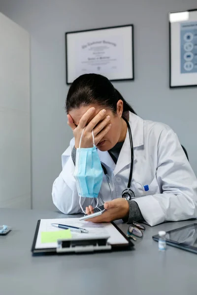 Médica preocupada com as mãos no rosto — Fotografia de Stock