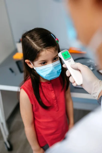 Mädchen ohne Fieber, dessen Temperatur von ihrem Arzt gemessen wird — Stockfoto