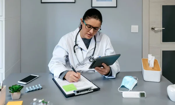 여성 의사가 태블릿으로 온라인상에서 상담하는 모습 — 스톡 사진