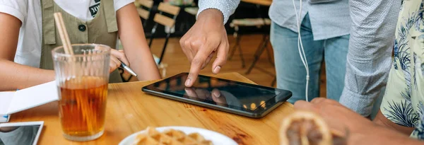 Amigos irreconhecíveis usando tablet em uma cafeteria — Fotografia de Stock