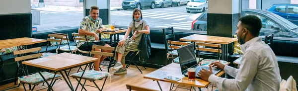 Jeune homme télétravail dans le café parler à des amis maintenir — Photo