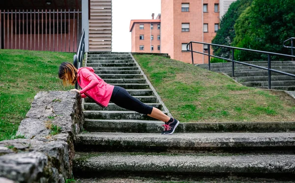 Atleta feminina fazendo flexões ao ar livre — Fotografia de Stock