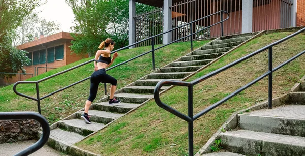 Atleta femenina subiendo escaleras al aire libre — Foto de Stock