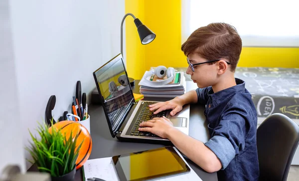 Мальчик делает домашнее задание с ноутбуком — стоковое фото