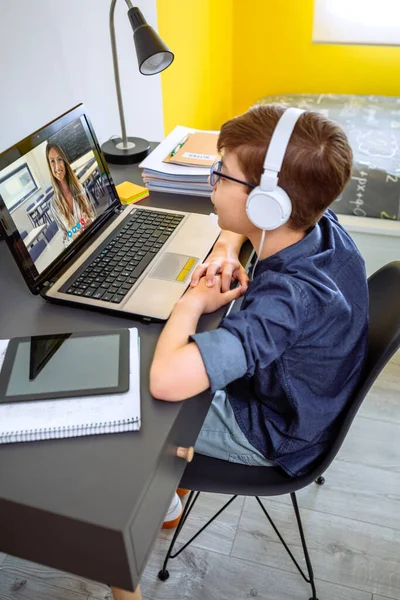 Preteen met hoofdtelefoon ontvangen klasse thuis met laptop uit zijn slaapkamer — Stockfoto