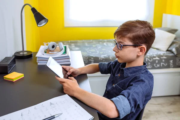 Preteen doing homework with a tablet — Stockfoto