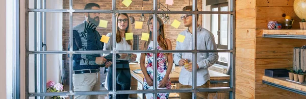 Gli uomini d'affari in una riunione di lavoro mettendo appunti appiccicosi sul wa — Foto Stock