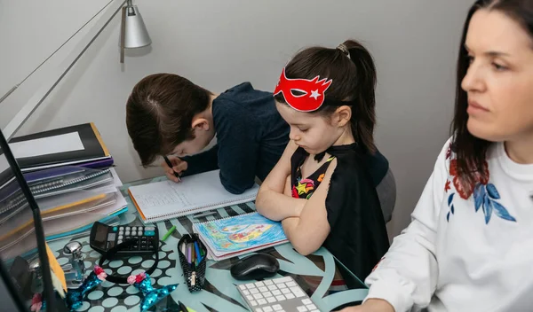 Mujer teletrabajando con su hijo y su hija enojada —  Fotos de Stock