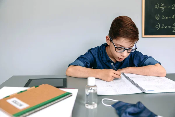 Αγόρι που γράφει στο σημειωματάριό του στο σχολείο — Φωτογραφία Αρχείου