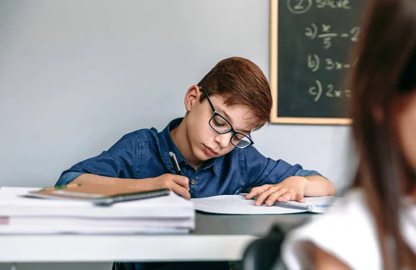 Αγόρι που γράφει στο σημειωματάριο στο σχολείο — Φωτογραφία Αρχείου