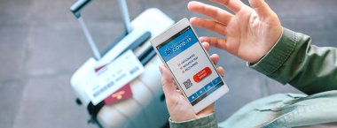 Pasaportu reddedilmiş bir cep telefonu tutan eller.
