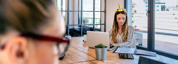 Businesswoman with unicorn headband working — Stock Photo, Image