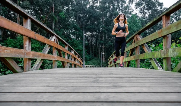 Mujer corriendo por un parque urbano — Foto de Stock