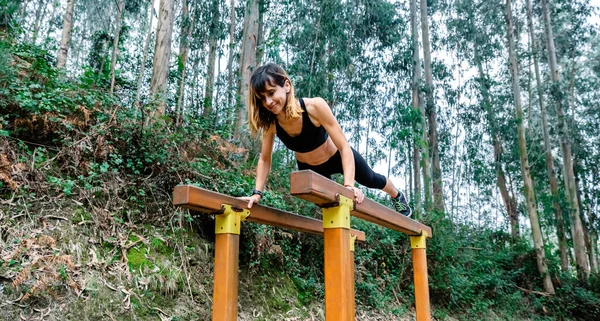 Atleta mulher treinando em barras paralelas — Fotografia de Stock