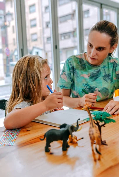 Mother explaining homework to her daughter — Stock Photo, Image