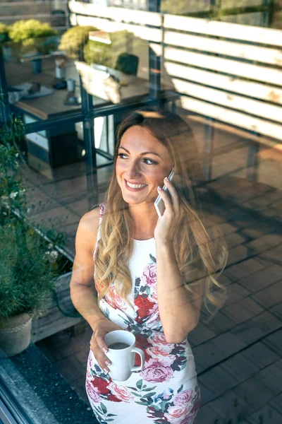 Frau telefoniert mit Kaffeetasse — Stockfoto