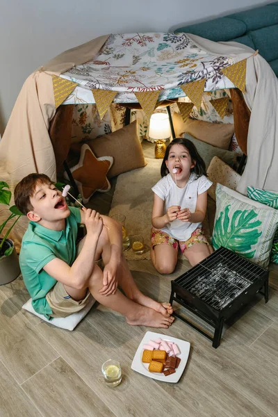 Chico y chica divirtiéndose comiendo malvaviscos — Foto de Stock