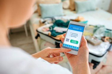 Bavulu hazırlayan kadın ve dijital yeşil geçiş kartı.