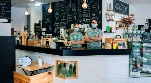 Владельцы кафе позируют в масках — стоковое фото