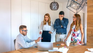 Yönetim ekibi, ofiste beceriksiz bir işçiyi azarlıyor.