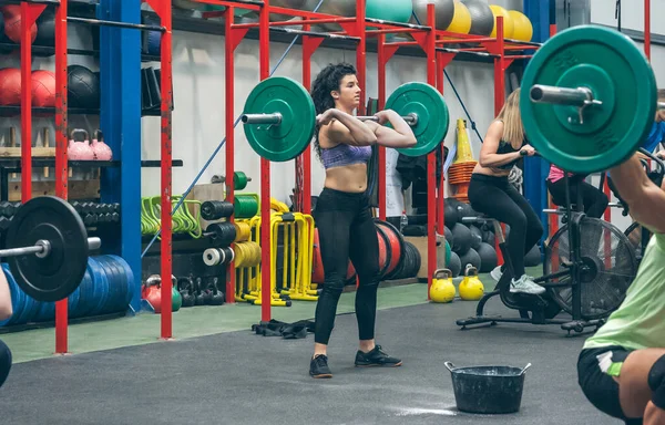 Spor salonunda ağırlık kaldıran bir kadın. — Stok fotoğraf