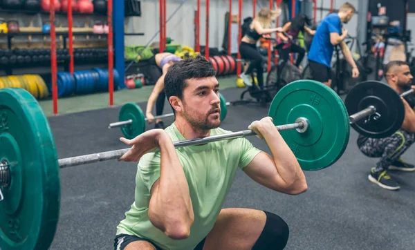 Spor salonunda ağırlık kaldıran bir adam. — Stok fotoğraf