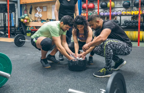 Compañeros de gimnasio aplicando magnesio para practicar levantamiento de pesas —  Fotos de Stock