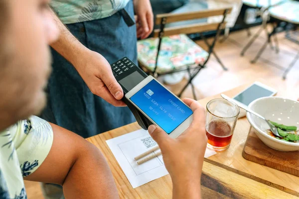 Cliente pagando la factura del restaurante con una tarjeta móvil virtual — Foto de Stock