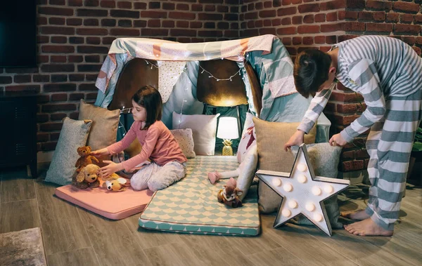 Male teenager helping little sister prepare a diy tent — Stock Photo, Image