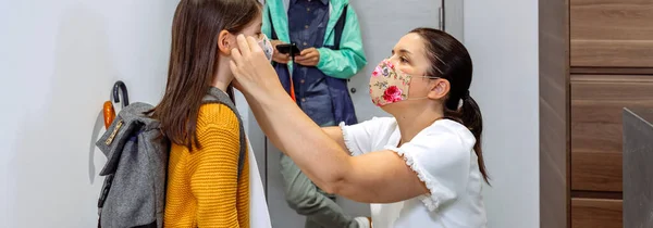 Matka zakłada maskę córce. — Zdjęcie stockowe