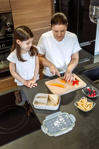 Mother preparing healthy snack for her daughter for school — Stock Photo, Image