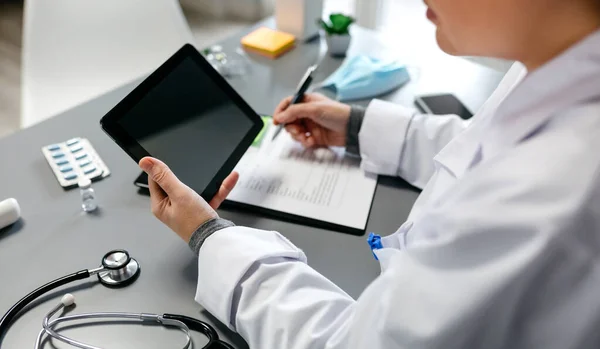 Ärztin bei der Arbeit mit Tablet nicht wiederzuerkennen — Stockfoto