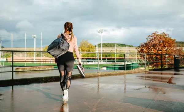 穿着运动包和运动鞋步行去训练的不明身份的女运动员 — 图库照片