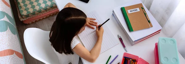 Girl doing homework in her bedroom — Stock Photo, Image