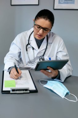 Kadın doktor tabletle çevrimiçi danışmanlık yapıyor.