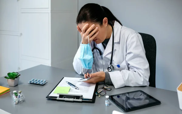 Besorgte Ärztin mit Händen im Gesicht — Stockfoto