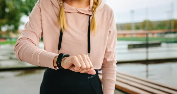 Jonge sportvrouw op zoek activiteit armband — Stockfoto