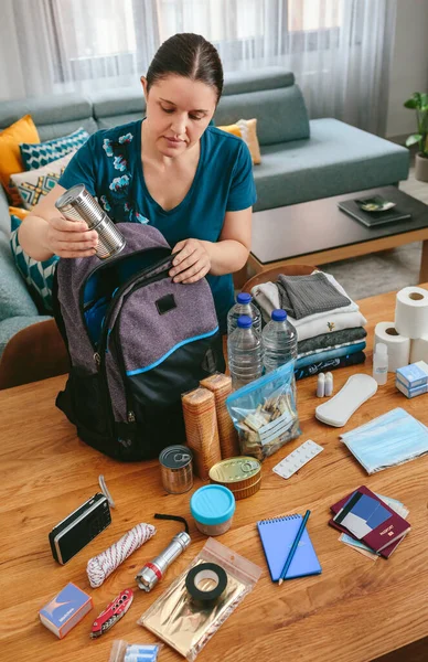 Frau stellt Konservendosen für Notfallrucksack bereit — Stockfoto